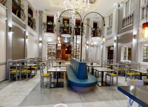 een restaurant met tafels en stoelen en een blauwe bank bij Pietrak Hotel in Gniezno