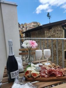 a table with a plate of food and wine glasses at Scilla's Dream in Scilla
