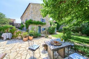 a patio with a table and chairs in front of a building at HERITAGE Villa DEA RUSTICA in Malinska
