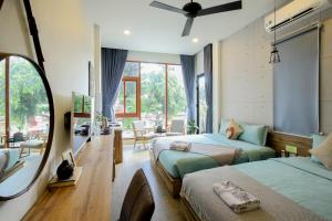 a bedroom with two beds and a mirror at Magnolia's Can Tho in Can Tho