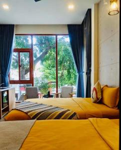 a bedroom with two beds and a large window at Magnolia's Can Tho in Can Tho +39 photos