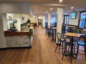 a restaurant with tables and chairs and a bar at Empire Hotel Goulburn in Goulburn
