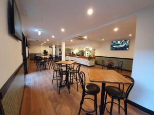 a restaurant with tables and chairs and a bar at Empire Hotel Goulburn in Goulburn