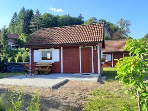 a small red and white house with a patio at Ferienhaus am Zainhammer in Brotterode-Trusetal