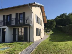 Cette maison blanche dispose d'un balcon sur le côté. dans l'établissement Gite Amélie, Sauna, Spa au coeur des Vosges, à Housseras