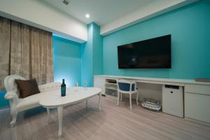 HOTEL LASCALA في واكاياما: غرفة معيشة مع طاولة بيضاء وتلفزيون