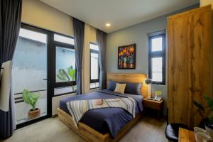 a bedroom with a bed and some windows at Magnolia's Can Tho in Can Tho