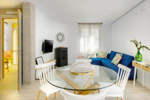 sala de estar con mesa de cristal y sofá azul en Selbaondoa, Casa con Patio en el Prepirineo Navarro, en Lumbier