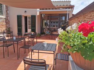 a patio with tables and chairs and flowers at L'Iris B&B in Terrazza in Lucca