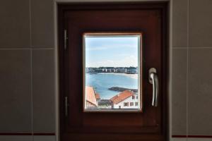 a door with a window looking out at the water at Hotel Agur Deneri in Ciboure