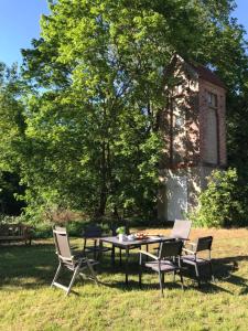 a table and chairs in front of a building at Gutshaus Alt-Jargenow in Alt Jargenow