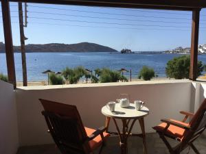 a table and chairs on a balcony with a view of the water at Asteri Hotel in Livadi