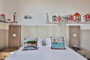 a bedroom with a bed with two pillows on it at Hotel Agur Deneri in Ciboure