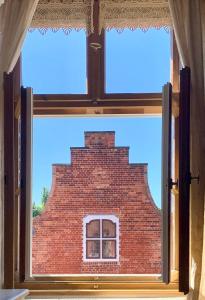 Blick auf ein Backsteingebäude durch ein Fenster in der Unterkunft Apartmenthaus im holländischen Viertel in Potsdam