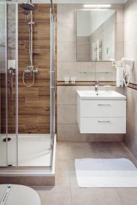 een badkamer met een douche en een wastafel bij Hotel Kaskada in Poprad