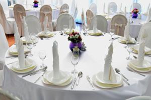a table with white plates and silverware on it at Hotel Josipdol in Josipdol