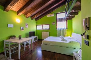 デセンツァーノ・デル・ガルダにあるGardappartamenti Carducci City Centreの緑の壁のベッドルーム(ベッド1台、テーブル付)