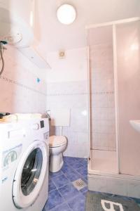 a bathroom with a washing machine and a toilet at Fri Apartment in Piran