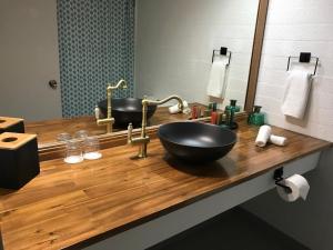 a bathroom with a sink, mirror, and soap dispenser at Greenmount Beach House in Gold Coast