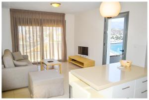 a living room with a couch a chair and a table at Potideon Bay Luxury Apartments in Karpathos