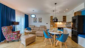 Il comprend une cuisine et un salon avec une table et des chaises. dans l'établissement Apartament 41 Holiday Mountain Residence - 5D Apartamenty, à Świeradów-Zdrój