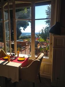 a dining room table with chairs and a large window at Le Belvedere des Remparts in Langres