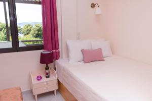 A bed or beds in a room at ILIOCHARI sea view apartments Oropos - Kalamos