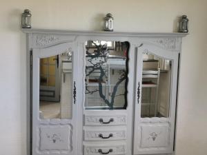 a white dresser with two mirrors in a room at Guest House Provencal in Vitrolles