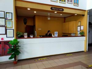 a woman sitting at a reception counter in a restaurant at Hotel Seri Malaysia Bagan Lalang in Sepang