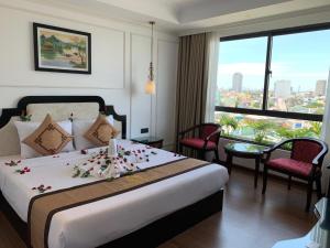 um quarto de hotel com uma cama com flores em Khanh Linh Hotel em Da Nang