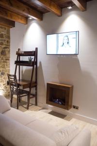 Una sala de estar con un sofá y un televisor en la pared. en Osabarena Hotela, en Murueta-Orozko