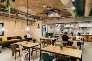 a restaurant with tables and people sitting at tables at GRAND HOSTEL LDK Osaka Shinsaibashi - Former The Stay OSAKA Shinsaibashi in Osaka