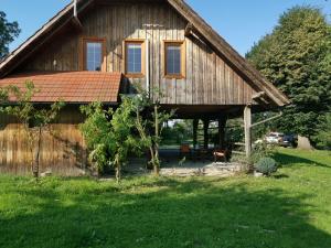 a large wooden house in a field of grass at Vetrovi šumijo I in Kapele