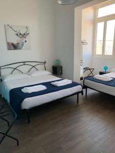 um quarto com 2 camas com lençóis azuis e brancos em Mambo Suites em Bolonha