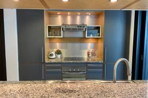 a kitchen with blue cabinets and a counter top at GuestReady - All That Jazz in Dubai