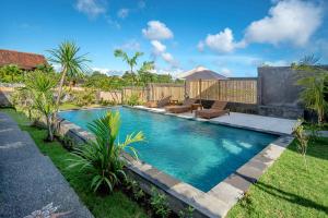 a swimming pool in the yard of a house at Private Room Kayu Bunga in Canggu