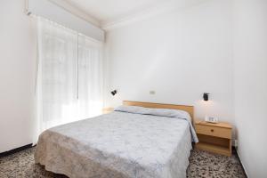 a white bedroom with a bed and a window at San Francisco rooms in Marina di Andora