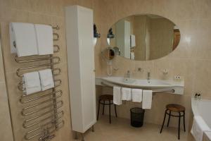 a bathroom with a sink and a mirror and towels at Hotel Bären in St. Moritz