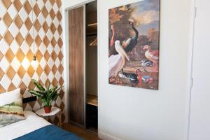 ein Schlafzimmer mit einem Flamingos-Gemälde an der Wand in der Unterkunft Quentin Golden Bear Hotel in Amsterdam