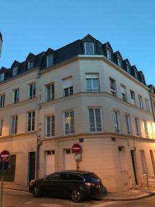 a black car parked in front of a large building at La Savane du Donjon in Rouen
