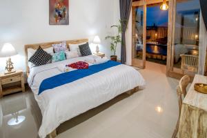 a bedroom with a large bed and a balcony at Private Room Kayu Bunga in Canggu +13 photos