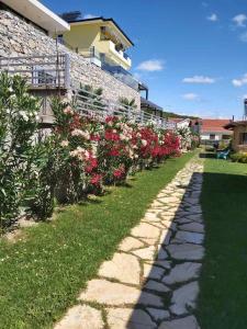 un sentiero in pietra di fronte a un edificio fiorito di Apartments and Villas Janev a Star Dojran