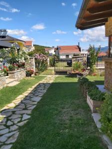 um quintal com uma passagem de pedra e relva verde em Apartments and Villas Janev em Star Dojran