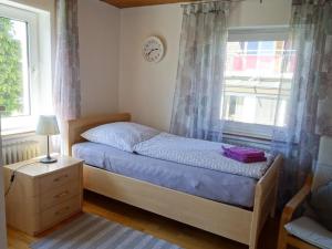 a bedroom with a bed and a window with a clock at Ferienwohnung Groß in Blaubeuren