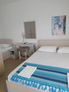 a small bedroom with a bed and a table at Apartments and Villas Janev in Star Dojran
