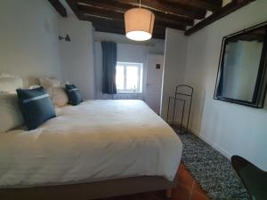 Un dormitorio con una gran cama blanca y una ventana en Les appartements du Domaine de Maffliers 4 étoiles - Demeures de Campagne en Maffliers