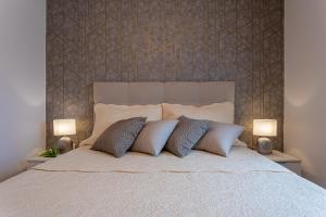 a white bed with two pillows and two lamps at Apartment Ivan in Sveti Ivan Dobrinjski