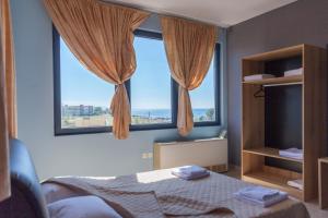 a bedroom with a bed and a large window at Via Mare Apartments in Alexandroupoli