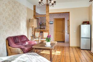 a living room with a couch a table and a refrigerator at Toma street apartments in Liepāja