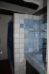 Baño de azulejos azules y blancos con lavabo en Maison de charme près de la mer en Bormes-les-Mimosas